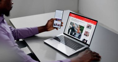 Cep telefonu ve dizüstü bilgisayarda online haber makalesi izliyorum. Elektronik Gazete