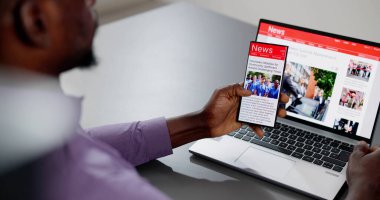 Cep telefonu ve dizüstü bilgisayarda online haber makalesi izliyorum. Elektronik Gazete