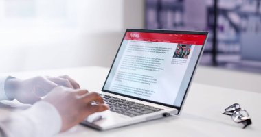 Dizüstü bilgisayardaki haber başlığını okuyorum. Çevrimiçi Web Sitesi