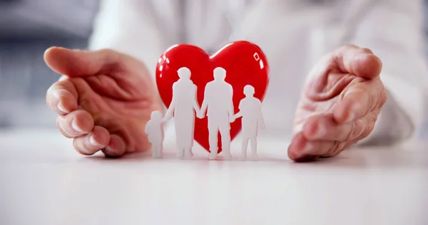 Health And Life Insurance. Heart Protected By Doctor