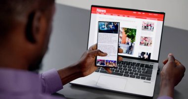 Cep telefonu ve dizüstü bilgisayarda online haber makalesi izliyorum. Elektronik Gazete