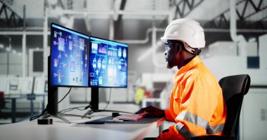 Elektrikli araba montaj fabrikasında bilgisayar kullanan Afrikalı Amerikalı mühendis.