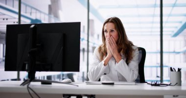 Hüsrana uğramış hastanedeki çok çalışan doktor bilgisayara bakıyor.