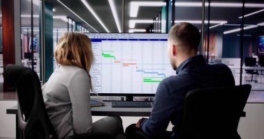 Gantt Çizelgesini Analiz Eden Genç İş Adamları ve Ofisteki Bilgisayarda Takvim