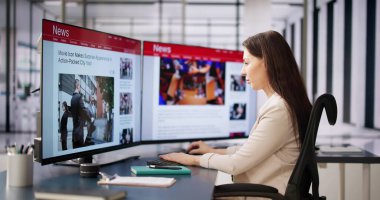 Çevrimiçi gazetede haberlere bakan kadın bilgisayarda