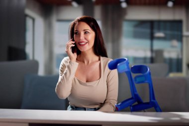 Bacağı yaralanmış bir hasta telefonda konuşuyor.