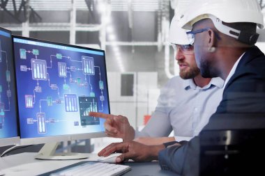 Afrikalı Amerikalı mühendis endüstriyel otomasyon sistemi bilgisayarı programlıyor