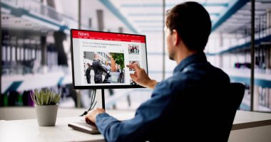 Adam Bilgisayar Ekranında Haber Okuma Sitesi