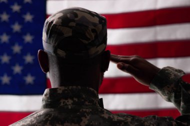 Amerikan askerleri askeri kampta Amerikan bayrağıyla selamlıyorlar.