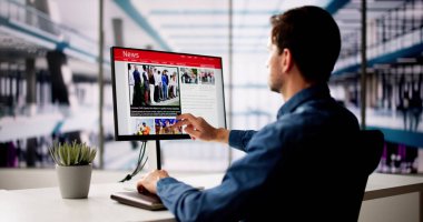 Adam Bilgisayar Ekranında Haber Okuma Sitesi