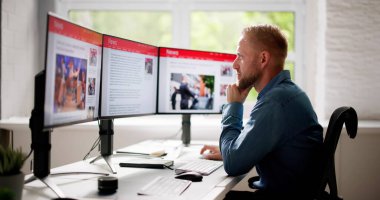 Adam Bilgisayar Ekranında Haber Okuma Sitesi