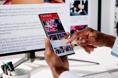 Cep telefonu ve dizüstü bilgisayarda online haber makalesi izliyorum. Elektronik Gazete