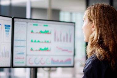 Mutsuz bir kadın iş yerindeki bilgisayar paneline bakıyor.