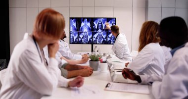 Çeşitli doktorlar MRT taramalarına bakıyor.