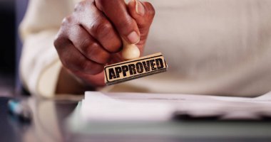 Afro-Amerikalı bir kadın noter olarak çalışıyor. Bir hukuk bürosunda siyah damgalı belgeleri onaylıyor..