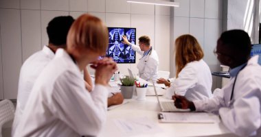 Çeşitli doktorlar MRT taramalarına bakıyor.