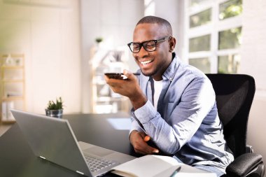Profesyonel Afro-Amerikan İş Adamı Modern Ofis Ayarlarında Akıllı Telefon Uygulaması Kullanıyor ve Sırıtıyor