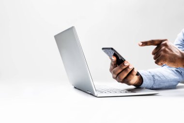 Odaklanmış Afrikalı Amerikalı adam, iş için dizüstü bilgisayar kullanıyor, e-ticaret işi için çevrimiçi varlık yönetiyor ve mali işlemleri izliyor.