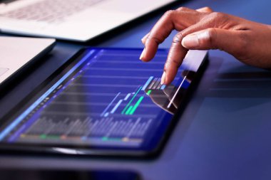 Gantt yazılımını kullanarak ofisteki bilgisayar hesaplarını kontrol eden Afrikalı Amerikalı kadın..