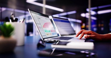 Dizüstü bilgisayarında Bütçe İzleyici Uygulaması ile finansman yönetimi. Afrikalı Amerikalı kadın online bankacılık hizmetleri için harcamaları takip ediyor. Ofis düzenleyicisi meşgul.