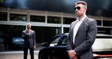 Şirket Yöneticisi Müşteri Güvenliği Ayarları 'nda profesyonel güvenlik görevlisi tarafından yüksek kaliteli lüks araba yakınında korunuyor..