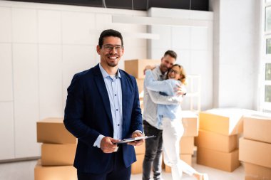 Profesyonel Emlakçı ve Yeni Evdeki Mutlu Müşteri Çifti