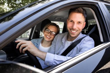 Yeni arabada oturan mutlu olgun çift