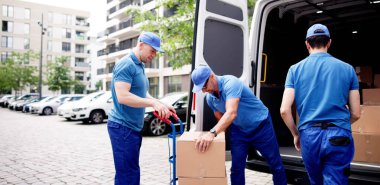 Efficient supply chain management in action: movers unloading cardboard boxes from delivery truck on busy urban street. Professions: mover, courier, manager. clipart