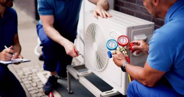 Tecrübeli bir havalandırma teknisyeni güvenlik donanımı ve kontrol listesiyle birlikte havalandırma tesisatı ve bakımı için ticari bina teftişi yapıyor. Profesyonel elektrikçi.