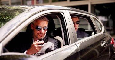 Yüksek profilli dedektif lüks bir arabanın içinde bir özel dedektif ve özel güvenlik görevlisiyle anlaşma yapıyor..