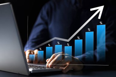 Başarılı Kafkasyalı işadamı dizüstü bilgisayardaki mali grafiği analiz ediyor, gelecekte büyümek ve refah yönetimi için yatırım kararları alıyor.