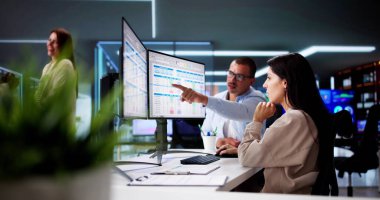 Bilgisayar Monitöründe Hesap Tablosu Verisiyle Çalışan İnsanlar