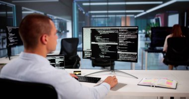 Afrika kökenli Amerikalı programcı masadaki bilgisayarı kullanıyor. Web Geliştirici
