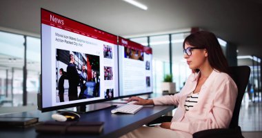 Çevrimiçi gazetede haberlere bakan kadın bilgisayarda