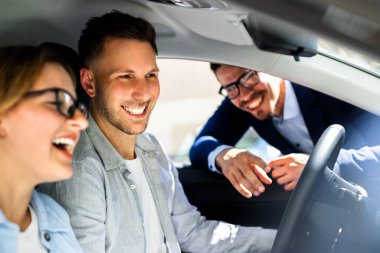 Profesyonel Araba Satıcısı Heyecanlı Şovlar Gösterişli Yeni Araç İçerideki Genç Çifte, İspanyol Kadın Direksiyon Sırıtışı.