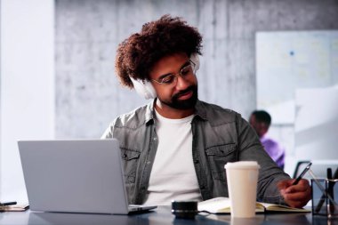 Çevrimiçi iş planlama ve dijital pazarlamacı olarak araştırma kursu için bilgisayar kullanan genç Afrikalı Amerikalı adam.