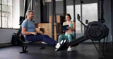 Spor Salonunda Kişisel Antrenör Kürek Çekme Makinası Çalışması