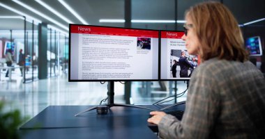 Çevrimiçi gazetede haberlere bakan kadın bilgisayarda