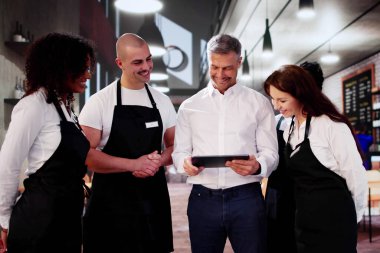 Kahve dükkanındaki mağaza müdürü ekiple toplantı yapıyor. Yönetim Planlaması