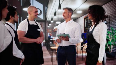 Kahve dükkanındaki mağaza müdürü ekiple toplantı yapıyor. Yönetim Planlaması