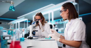 Laboratuvarda mikroskop kullanarak araştırma yapan tıp bilimci kadın.