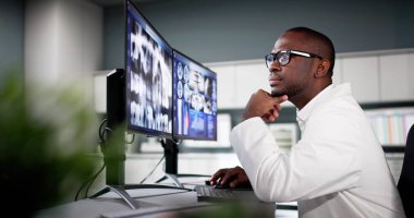 Diş hekimi bilgisayarda diş röntgenine bakıyor.