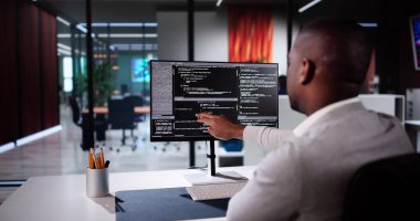 Afrika kökenli Amerikalı programcı masadaki bilgisayarı kullanıyor. Web Geliştirici