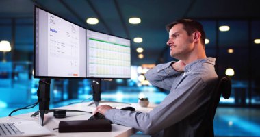 Ofis masasında otururken sırtı ağrıyan genç iş adamı