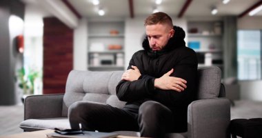 Sıcak giysiler evin içinde soğuk hissi ile genç adam