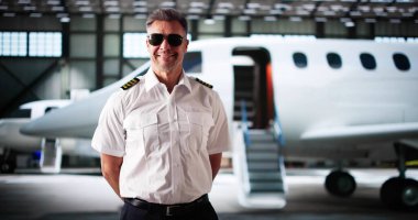 Üniformalı özel jet pilotu. Havaalanında küçük bir uçak.