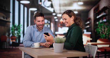 İş arkadaşları Teknoloji Yaşam Tarzını Kullanıyor. Kadın ve erkek kafede kahve içiyor.