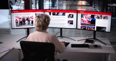 Çevrimiçi gazetede haberlere bakan kadın bilgisayarda