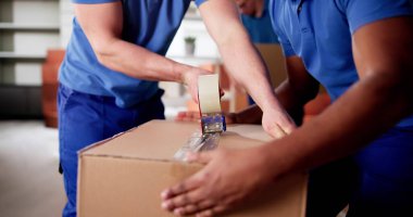 Çok ırklı Taşımacılar Aileleri Dikkatli Taşımak İçin Karton Kutuları Paketliyor.