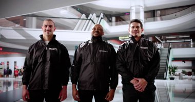 Güvenlik görevlileri alışveriş merkezinde durup perakende satış mağazalarını koruyorlar..